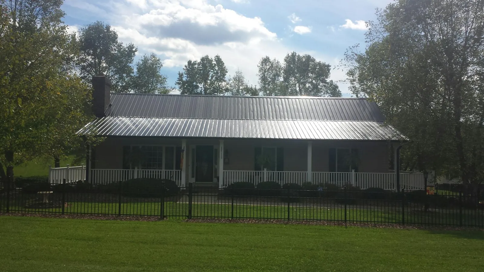 Gray metal roof on a brick ranch with a full width front porch — Gutter Guard Installation work by our crew in Twin Falls