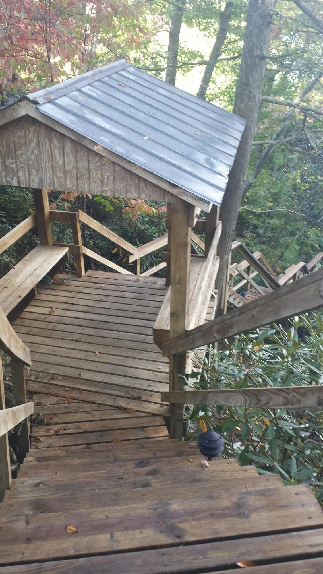 Metal roofed shelter over wooden steps on a wooded walkway — Skylight Repair & Installation work by our crew in Twin Falls