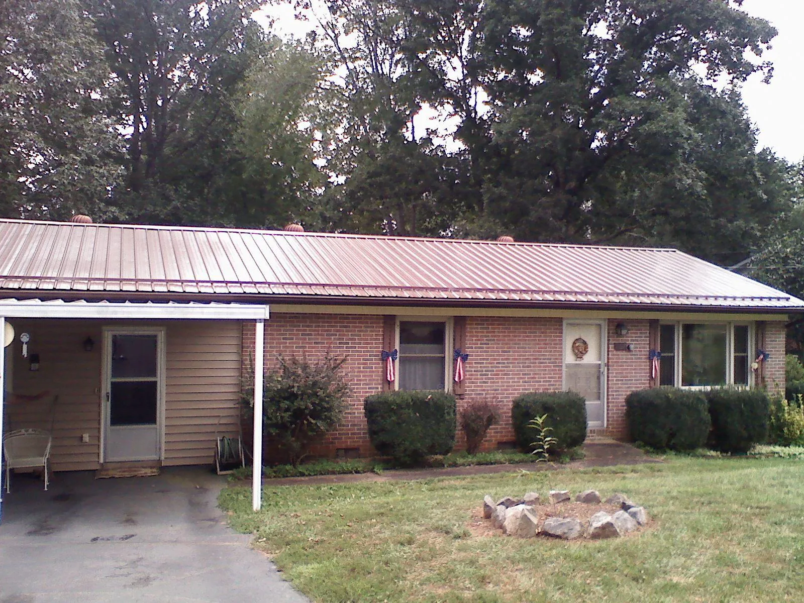 Bronze metal roof and carport on a brick ranch home — Roof Repair work by our crew in Twin Falls