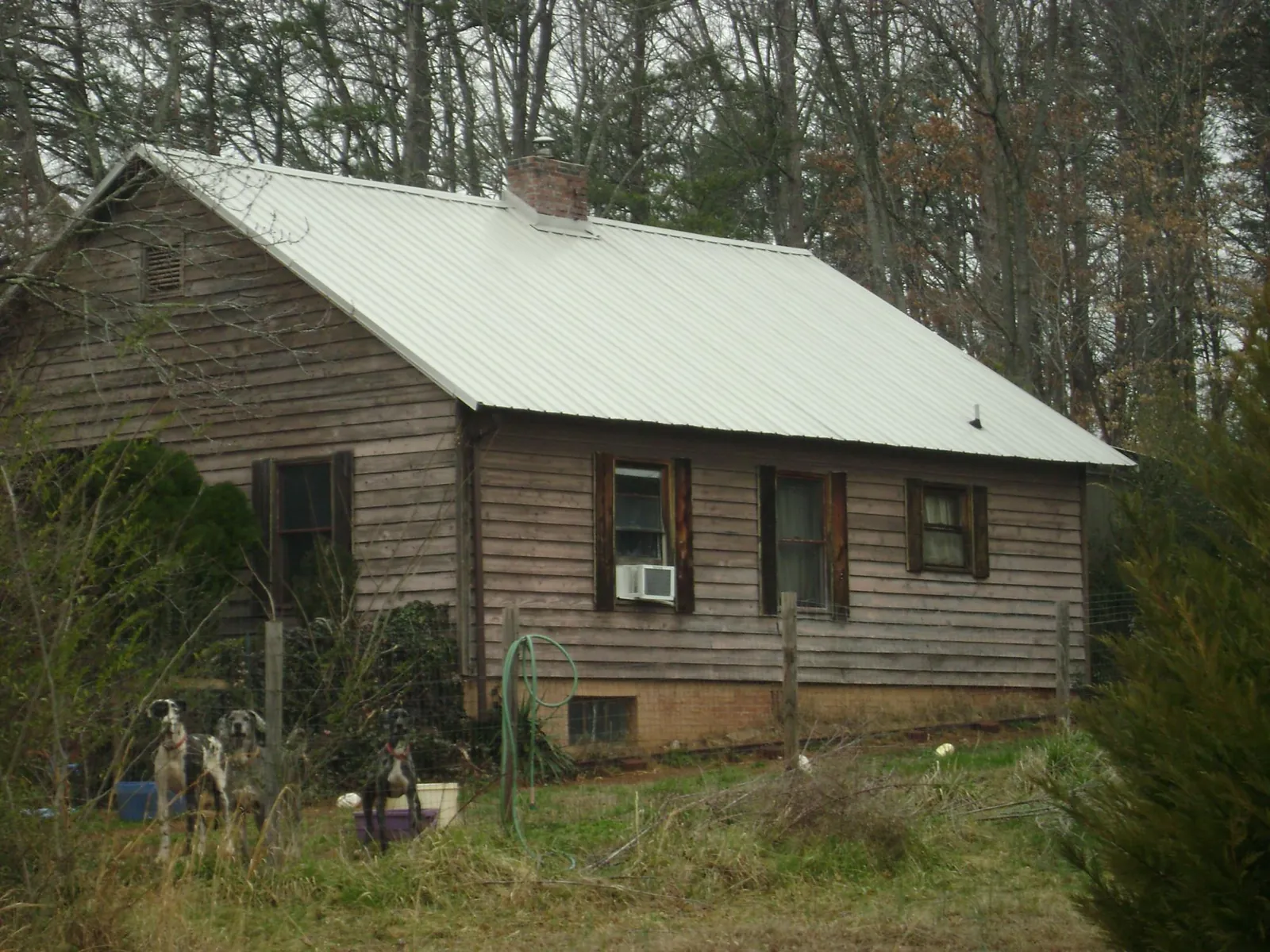 White metal roof on an old wood sided farmhouse, from a Metal Roof Installation job in Twin Falls